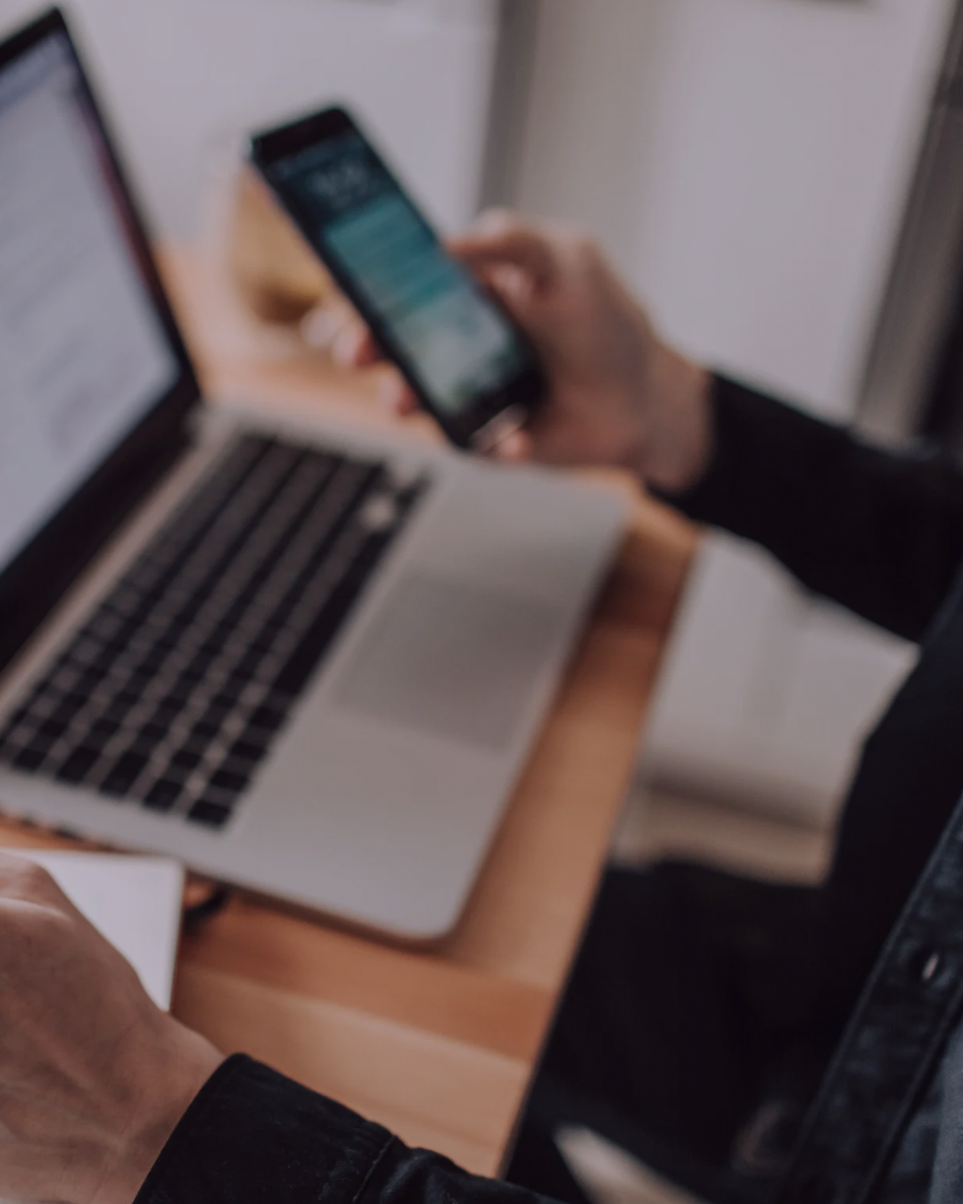 A male marketer comparing analytics on a laptop and a phone